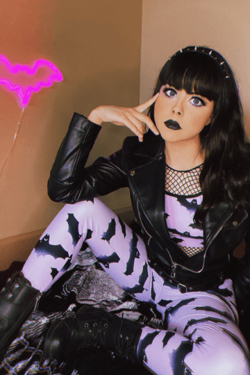Kawaii fashion with a stylish model in a bat-patterned outfit and edgy leather jacket, showcasing a playful vibe.
