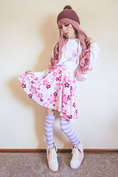 Cute fashion outfit featuring a pink floral skirt, cozy white hoodie, and striped socks in kawaii style.